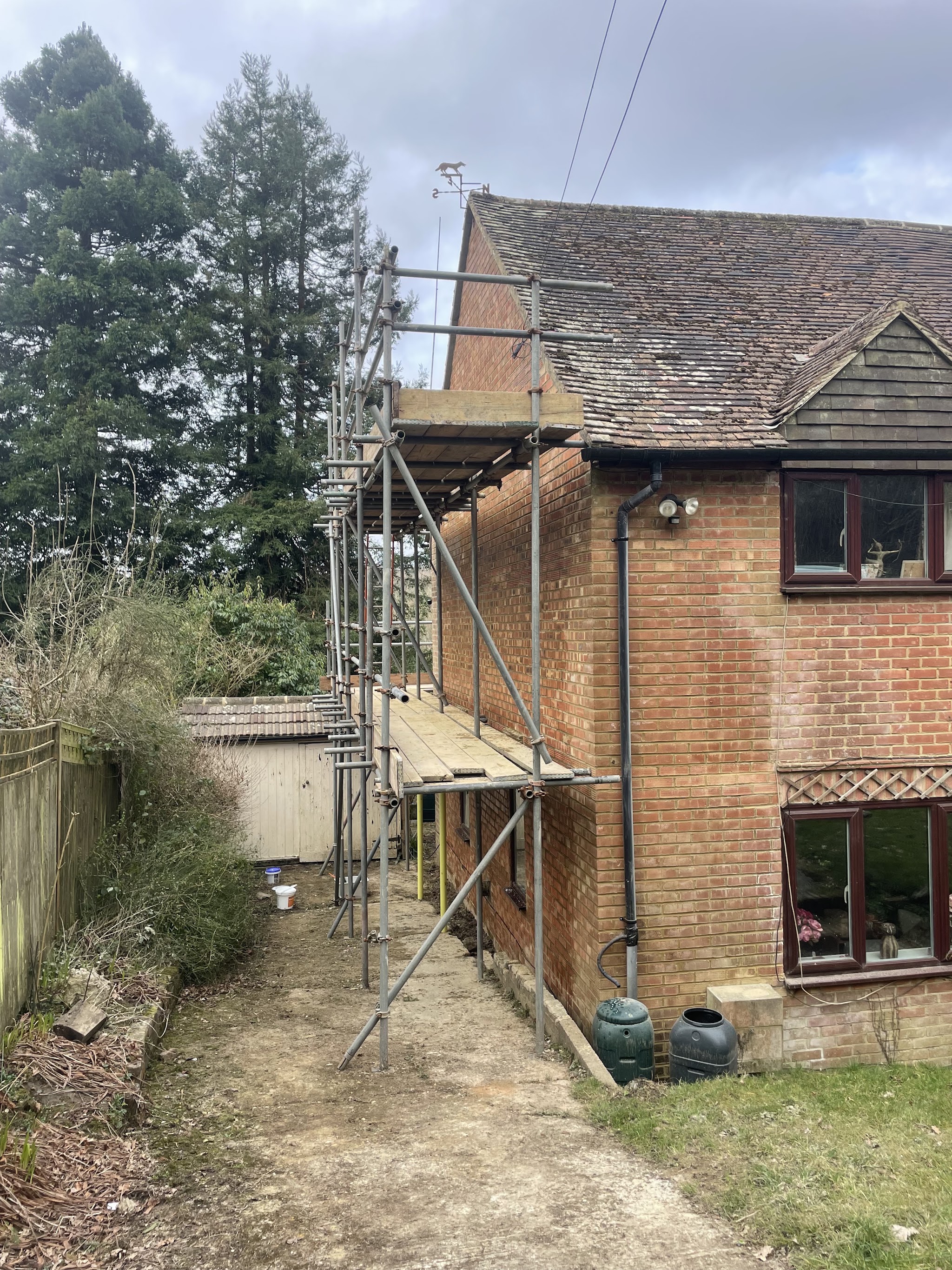 Scaffold up alongside an older brick cottage